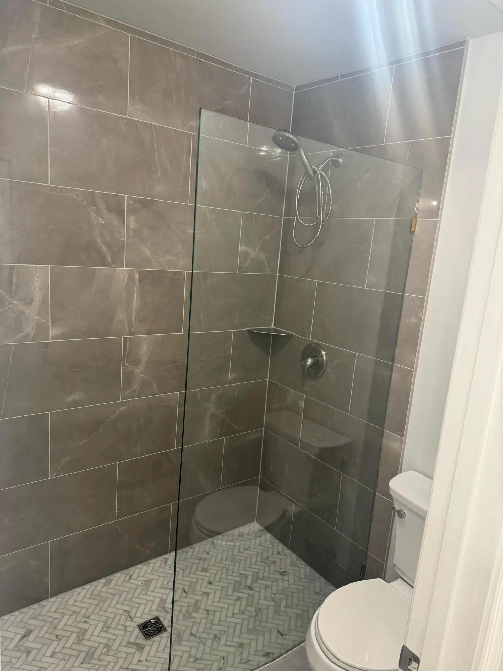 Frameless glass shower enclosure detail in Maryland bathroom